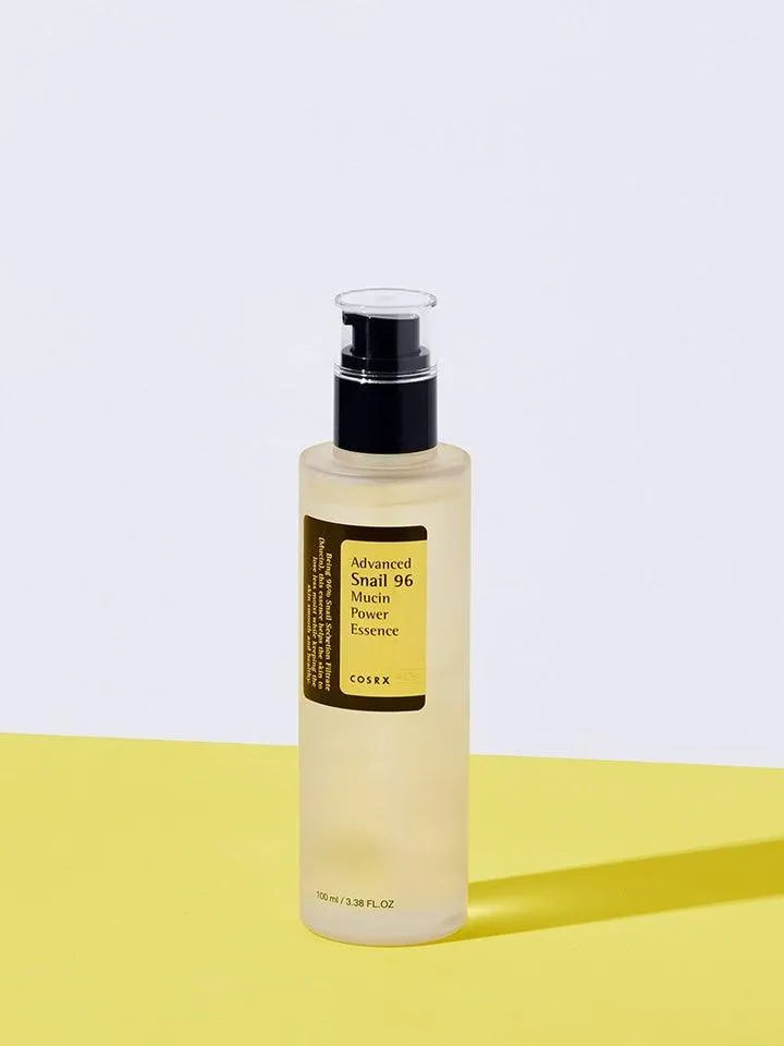 COSRX Advanced Snail 96 Mucin Power Essence bottle on yellow surface, Korean skincare