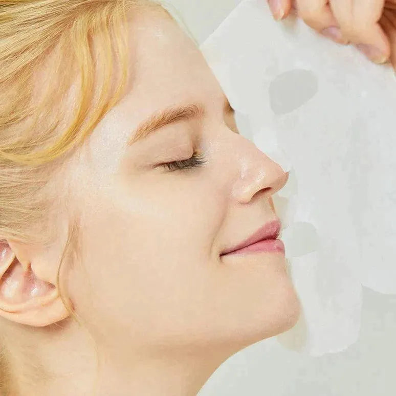 Woman applying COSRX Advanced Snail Mucin Power Sheet Mask, Korean skincare at Me Time Groningen