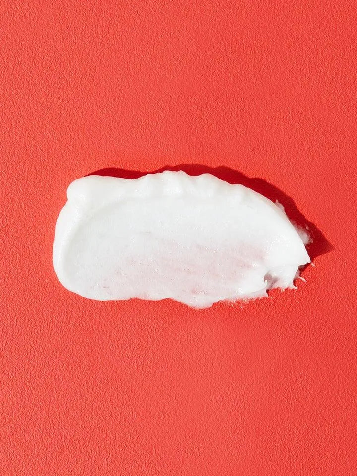 COSRX Salicylic Acid Daily Gentle Cleanser cream texture on red background, Korean skincare