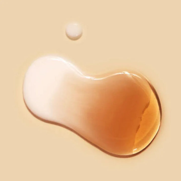 Dr. Ceuracle Vegan Kombucha Tea Essence texture, creamy and amber liquid on beige background