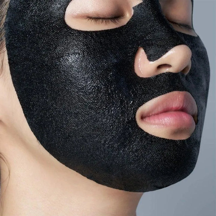 Close-up of a person wearing a black Korean sheet mask for pore care, skincare at Me Time Groningen