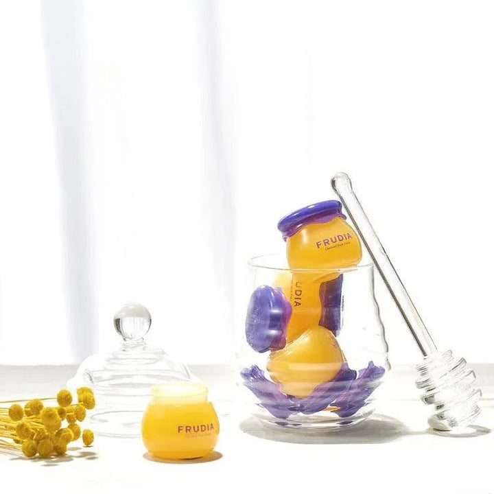 Frudia Blueberry Hydrating Honey Lip Balm jars with glass honey dipper on white background, Korean skincare product at Me Time Groningen.