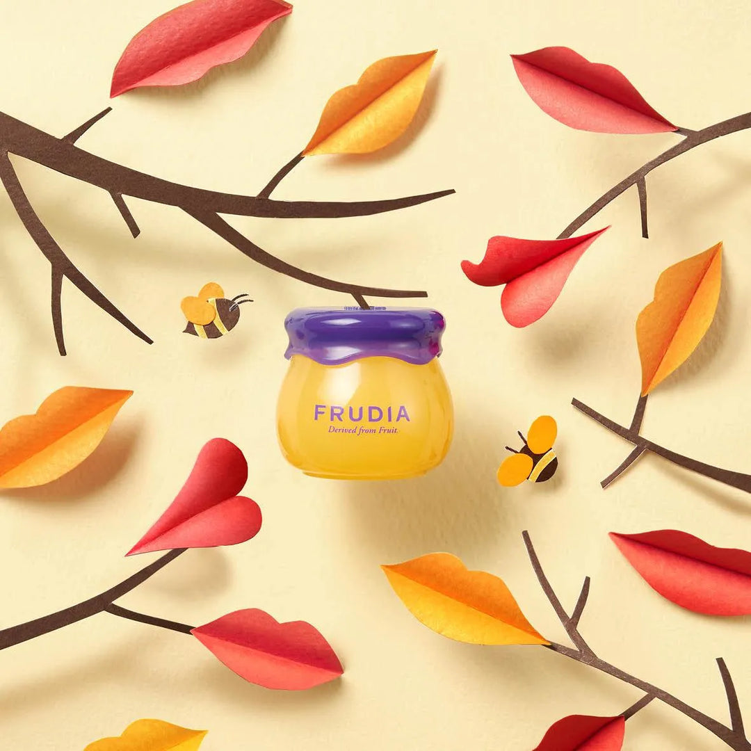Frudia Blueberry Hydrating Honey Lip Balm on pastel background with autumn leaves and bees, Korean skincare Nederland