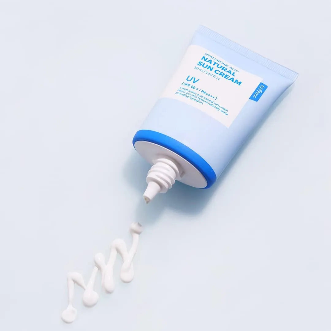 Isntree Hyaluronic Acid Natural Sun Cream tube with cream swirled on light blue background, Korean skincare shop