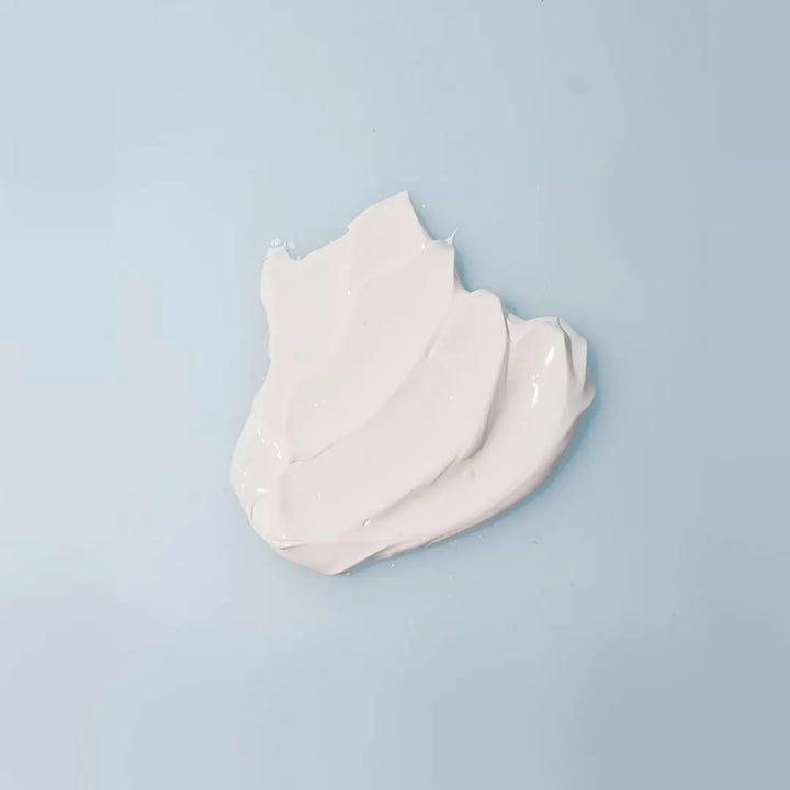 Texture of Isntree Hyaluronic Acid Natural Sun Cream on light blue background, Korean skincare