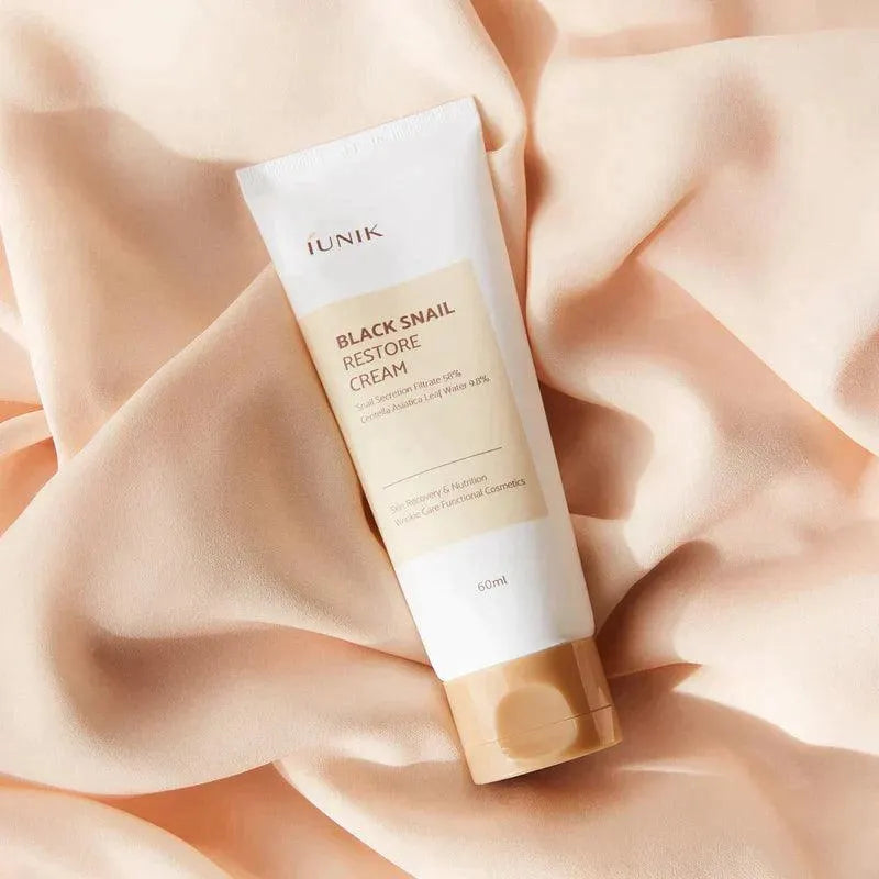 iUNIK Black Snail Restore Cream tube on soft beige fabric, Korean skincare Me Time Groningen
