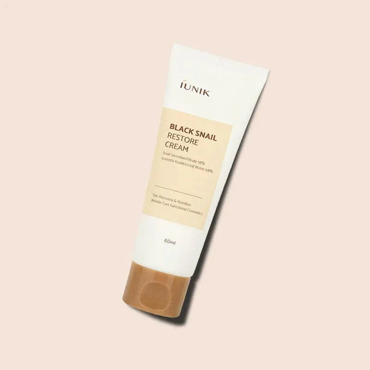 iUNIK Black Snail Restore Cream tube on beige background, Korean skincare at Me Time Groningen