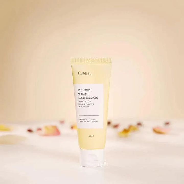 iUNIK Propolis Vitamin Sleeping Mask tube on a white surface with soft petals, Korean skincare Nederland