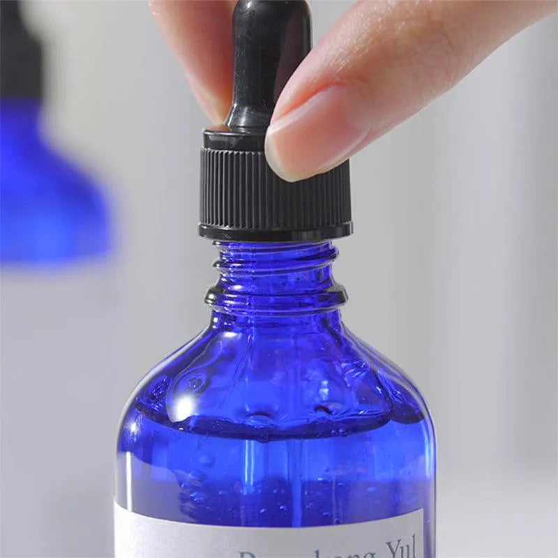 Hand holding Pyunkang Yul Moisture Ampoule dropper bottle, Korean skincare product