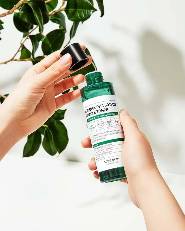 Hand holding Some By Mi AHA BHA PHA 30 Days Miracle Toner, Korean skincare product, green leaves background, Me Time Groningen